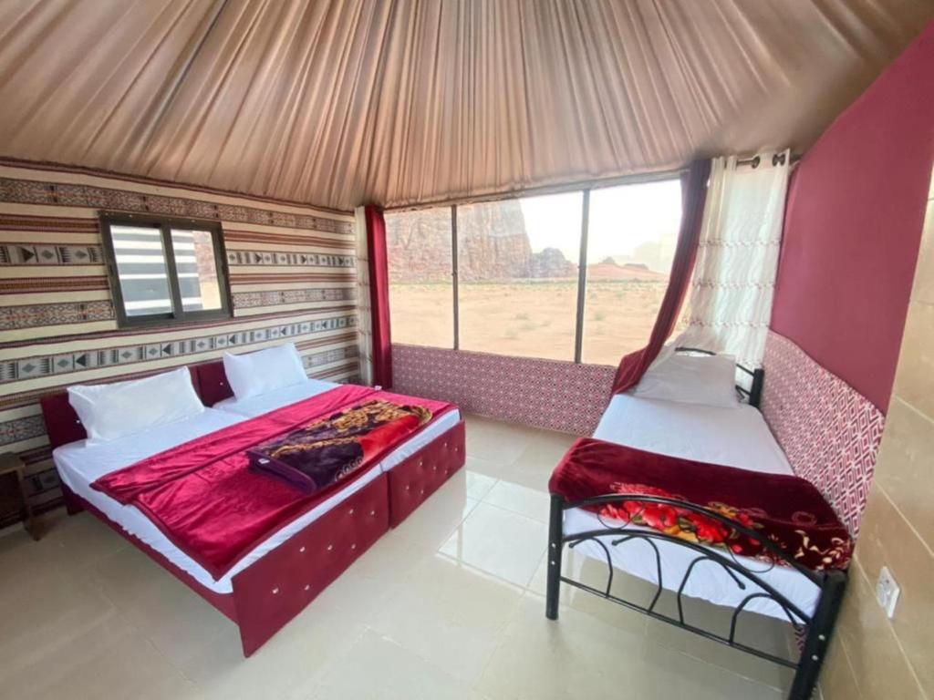 a bedroom with a bed and a window in a tent at Milky Way Nights Camp in Wadi Rum