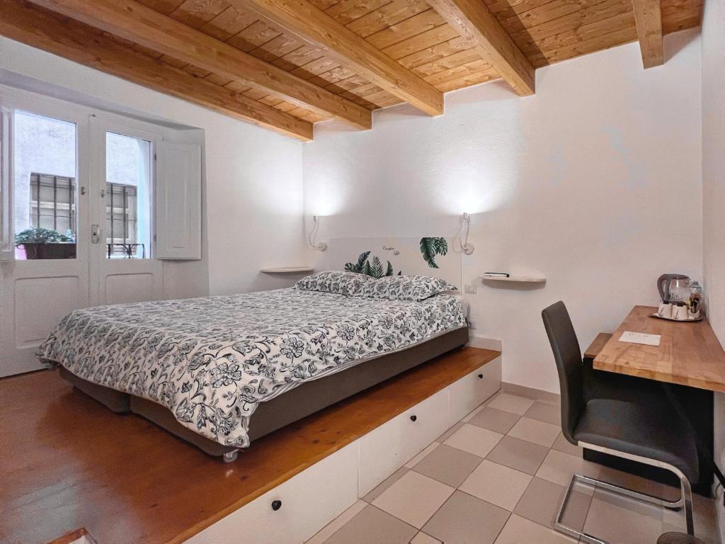 a bedroom with a bed and a desk at Al Duomo di Cagliari in Cagliari