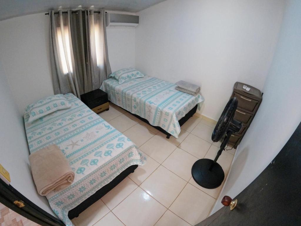 niewielka sypialnia z 2 łóżkami i stołem w obiekcie Apartamento Naufragio w mieście San Andrés