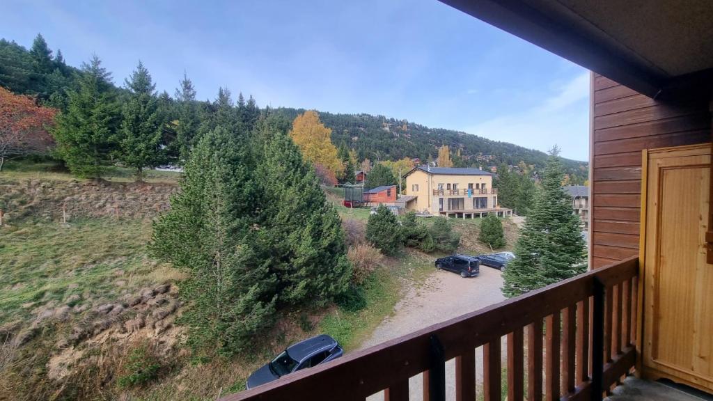 d'un balcon avec vue sur une maison et des arbres. dans l'établissement Bel appartement avec balcon, aux Angles