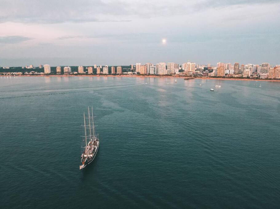 a boat in the water with a city in the background at Vintage Home en Pocitos in Montevideo