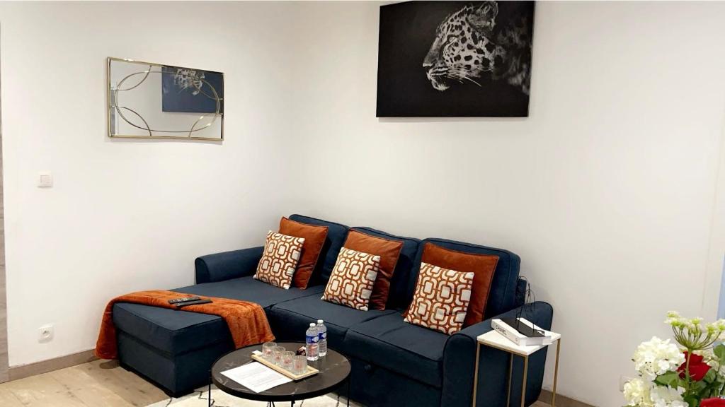 uma sala de estar com um sofá azul com almofadas em Calme, agréable et fonctionnel em Bruxelas