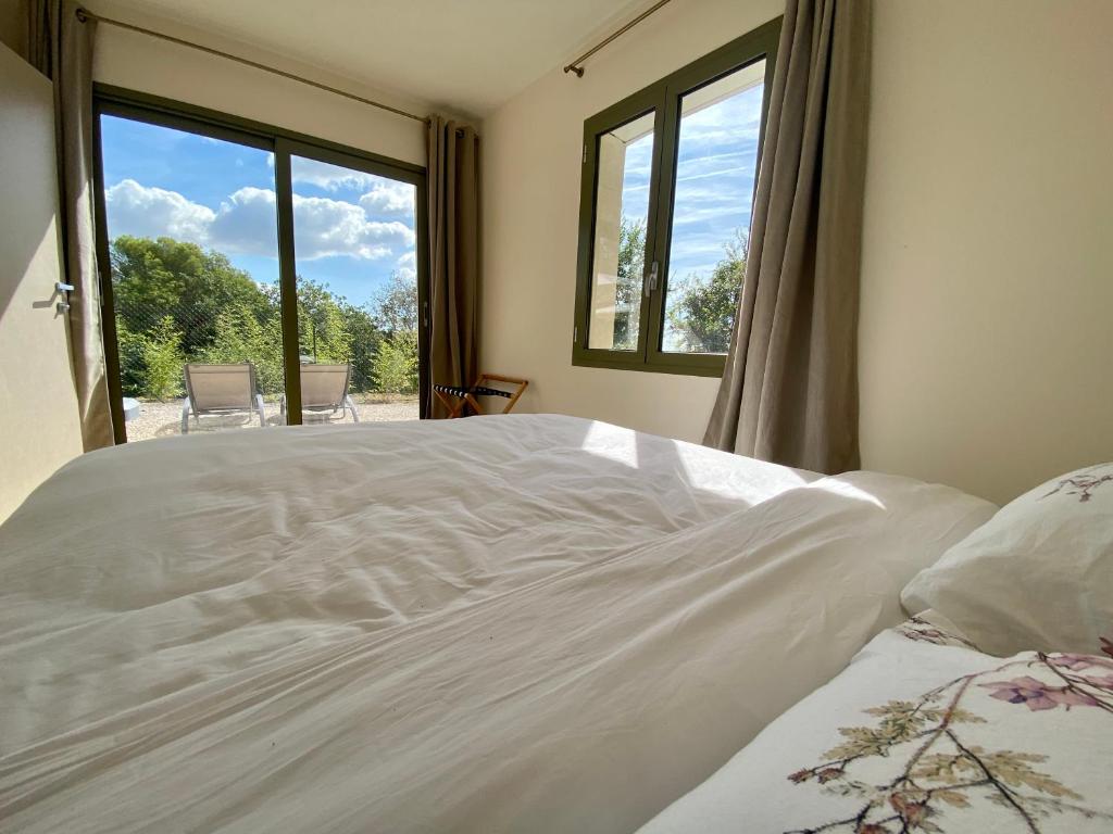a white bed in a room with a window at Villa Jacuzzi Calme & Elegance - Prox Mer - Clim & Cheminée - Parking in Cagnes-sur-Mer