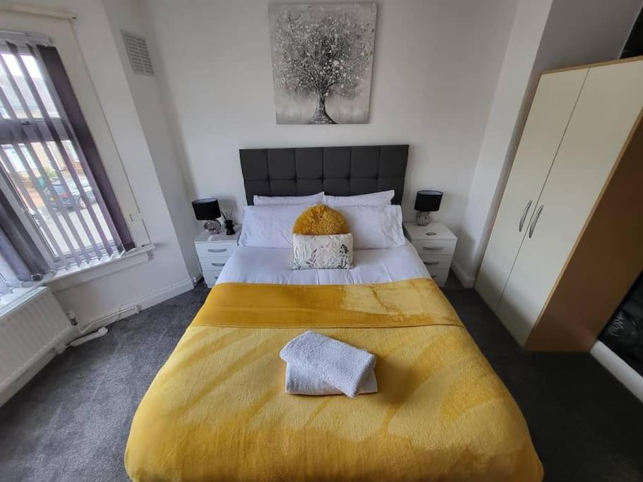 a bedroom with a large bed with a yellow blanket at 3 Bed Home - Sleeps up to 5 - Coventry - Contractors, Families and Relocators in Coventry