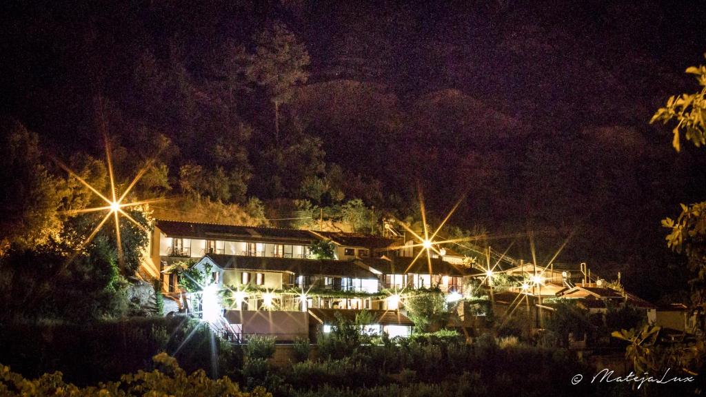 una casa iluminada por la noche con luces en Ambelikos Traditional Agrohotel, en Potamitissa