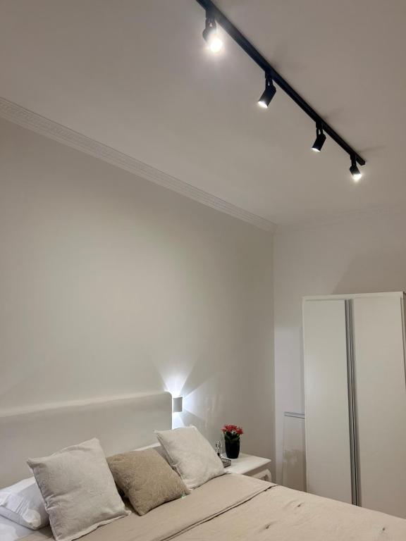 um quarto com uma parede branca e uma cama em apartamento reformado e bem localizado no Humaitá no Rio de Janeiro