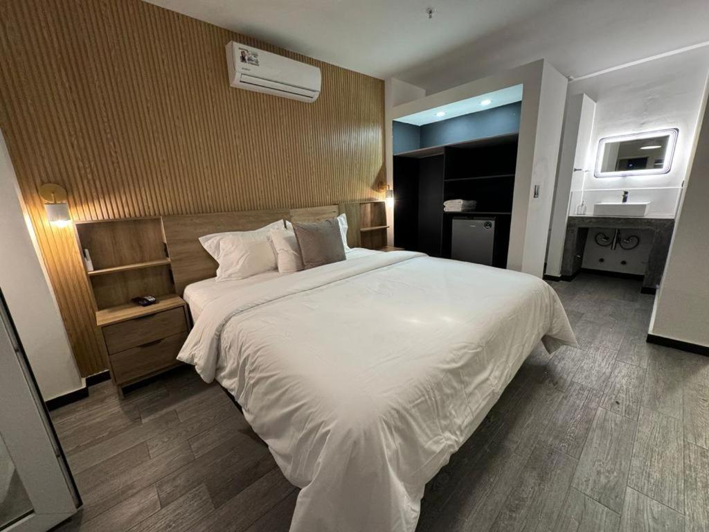 um quarto com uma grande cama branca num quarto em HOTEL BALUARTE BOUTIQUE PANAMA em Cidade do Panamá