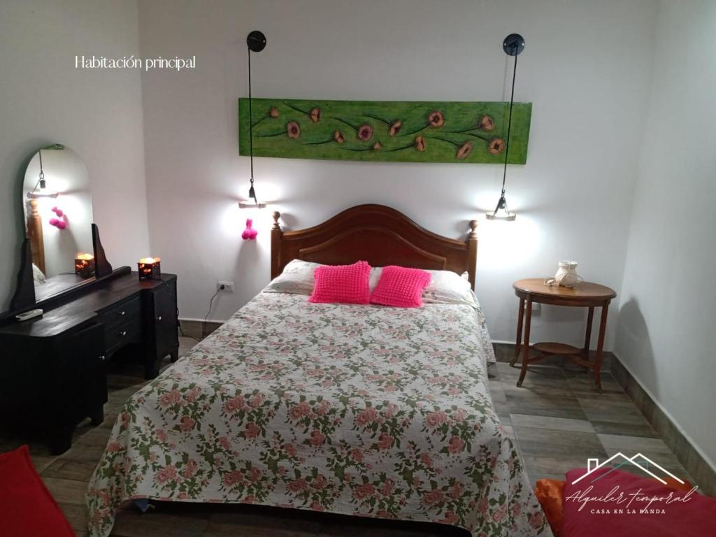 a bedroom with a bed with pink pillows on it at Casa temporaria Banda II in La Banda