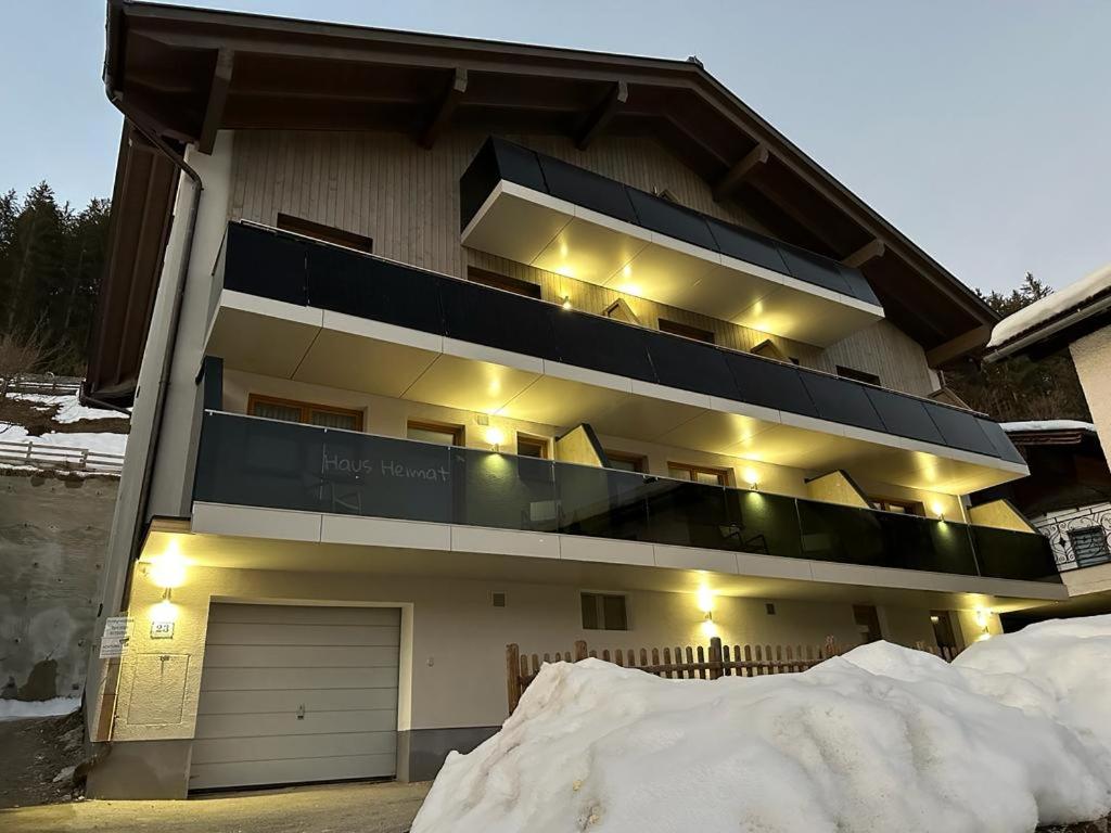 um prédio de apartamentos com neve em frente em Haus Heimat Wagrain em Wagrain