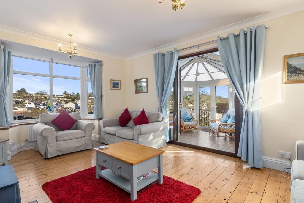 a living room with a couch and a table at Four Oaks - Sea and Harbour Views in Saundersfoot