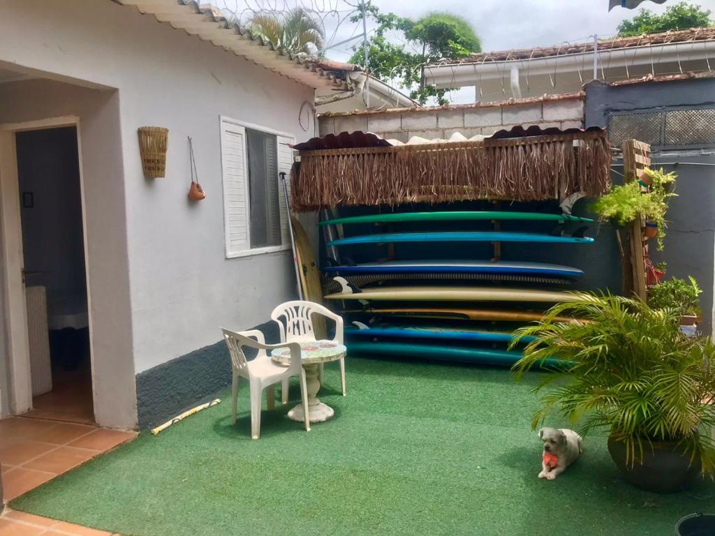 貝爾蒂奧加的住宿－SURFuncional Guest House，坐在房子前面绿色地毯上的狗