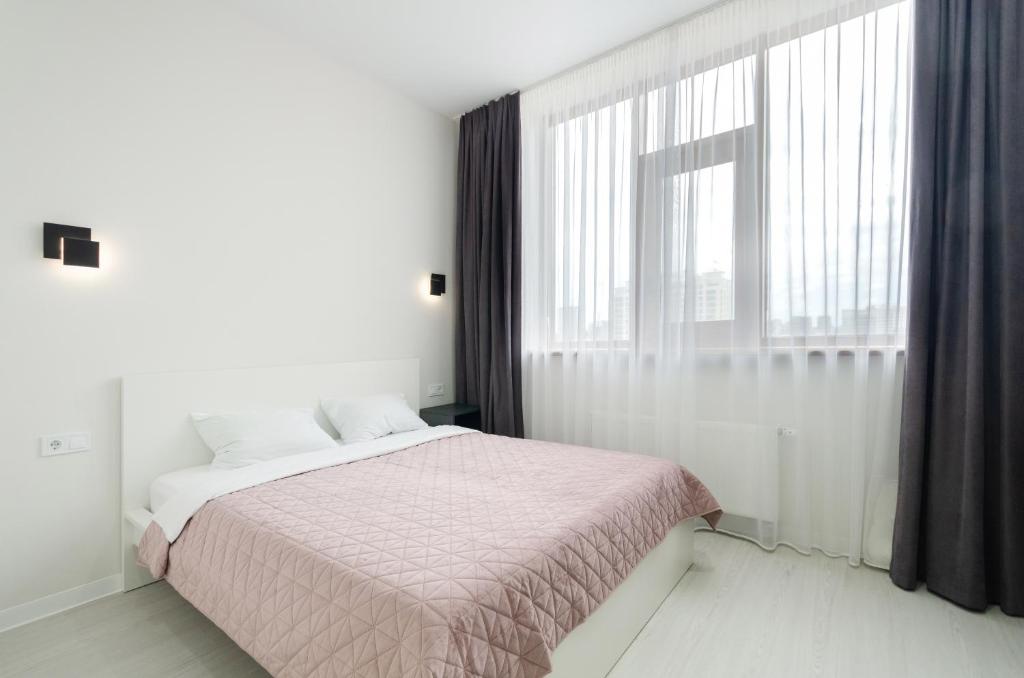 a bedroom with a bed and a large window at Smart hotel apartment with panoramic city view in Diplomat Hall in Kyiv