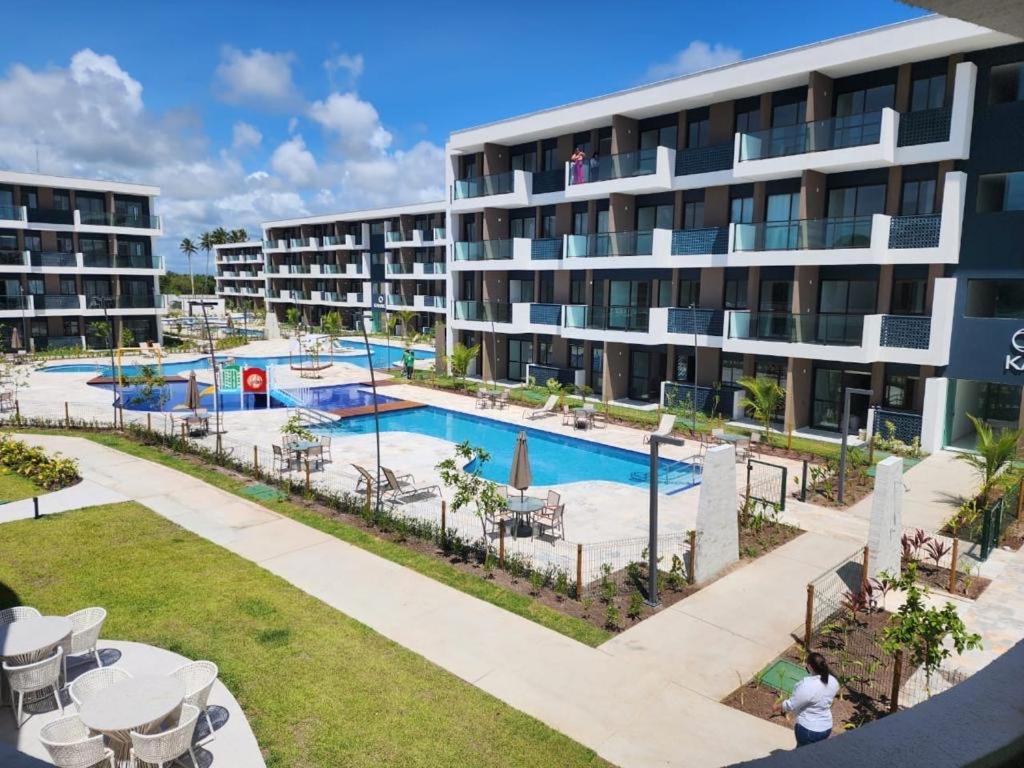 um complexo de apartamentos com uma piscina em frente a um edifício em Flat Sol do Makia - Studio com vista para piscina em Ipojuca