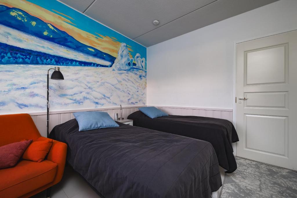 sypialnia z 2 łóżkami i obrazem na ścianie w obiekcie Pikkuriikkinen yksiö kaikilla herkuilla Levin keskustassa w mieście Kittilä