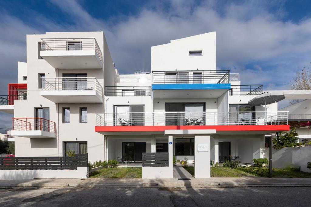 um edifício de apartamentos branco com varandas vermelhas e azuis em Pagani Green - Luxury Maisonette B3 em Kalamata