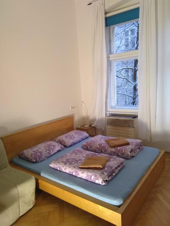 two twin beds in a room with a window at Comfy apartments in good area in Prague