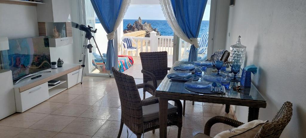 una sala da pranzo con tavolo e vista sull'oceano di SEA VIEW in Silent Residence South TENERIFE a Costa Del Silencio