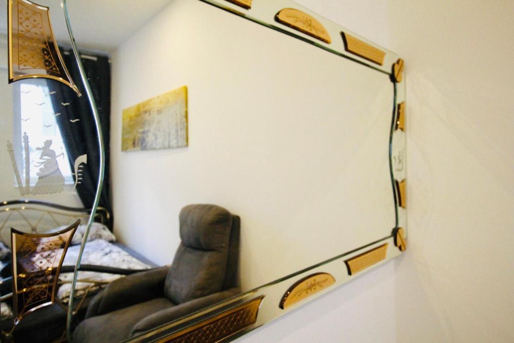 a mirror hanging on a wall with a chair at Luxury Apartment in Praterstern area in Vienna