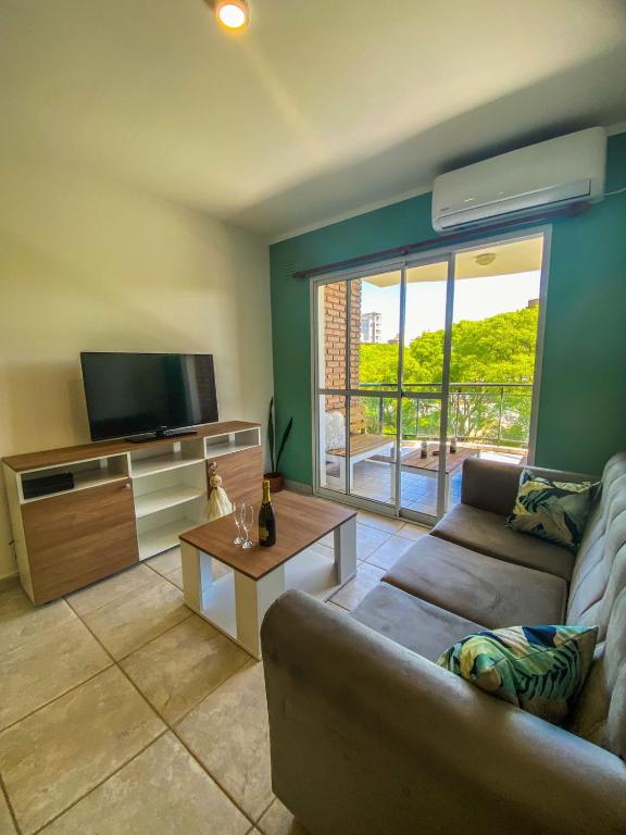 a living room with a couch and a flat screen tv at Departamento Good Vibes 2 in Paraná