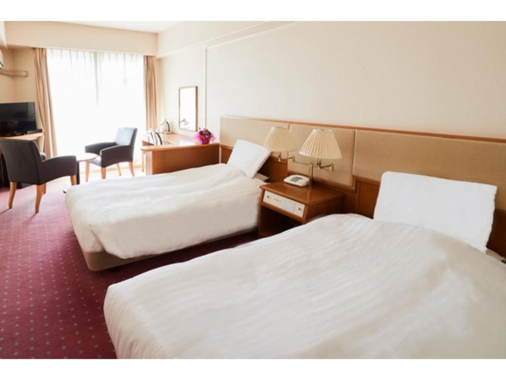 a hotel room with two beds and a desk at Hotel Crystal Palace - Vacation STAY 61208v in Hitachinaka