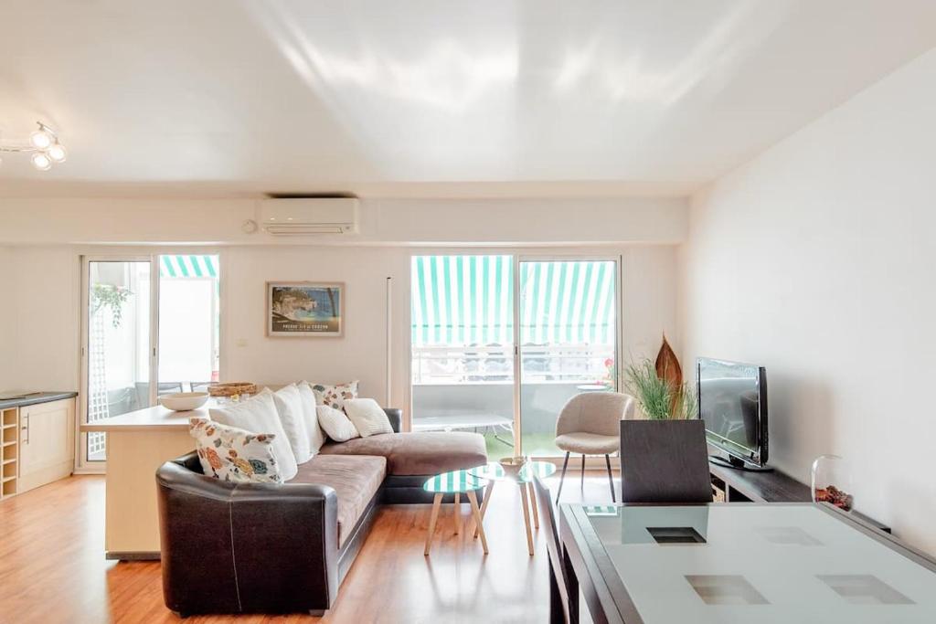 un salon avec un canapé et une table dans l'établissement Bright 2 Bed Apt in Cannes, 10 min to Palais, à Cannes