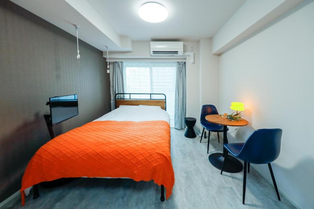 Schlafzimmer mit einem Bett, einem Tisch und Stühlen in der Unterkunft Seaside Tamachi - Vacation STAY 15580 in Tokio