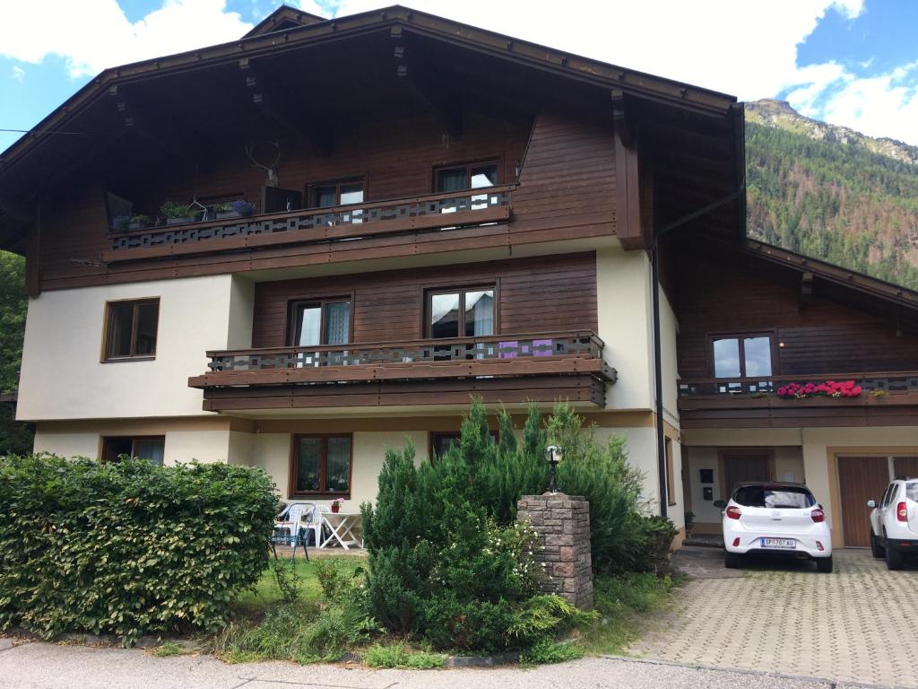 a large wooden house with cars parked in front of it at Haus Karin Mallnitz in Mallnitz