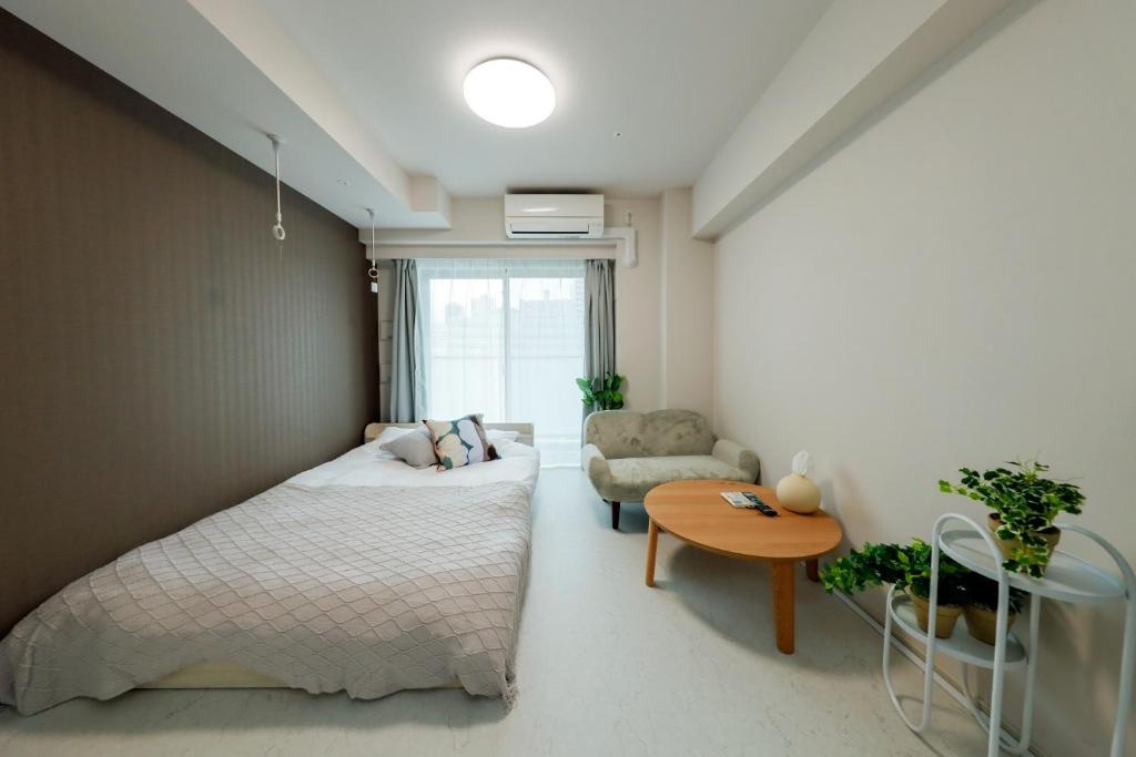 a bedroom with a bed and a couch and a table at Seaside Tamachi - Vacation STAY 15740 in Tokyo