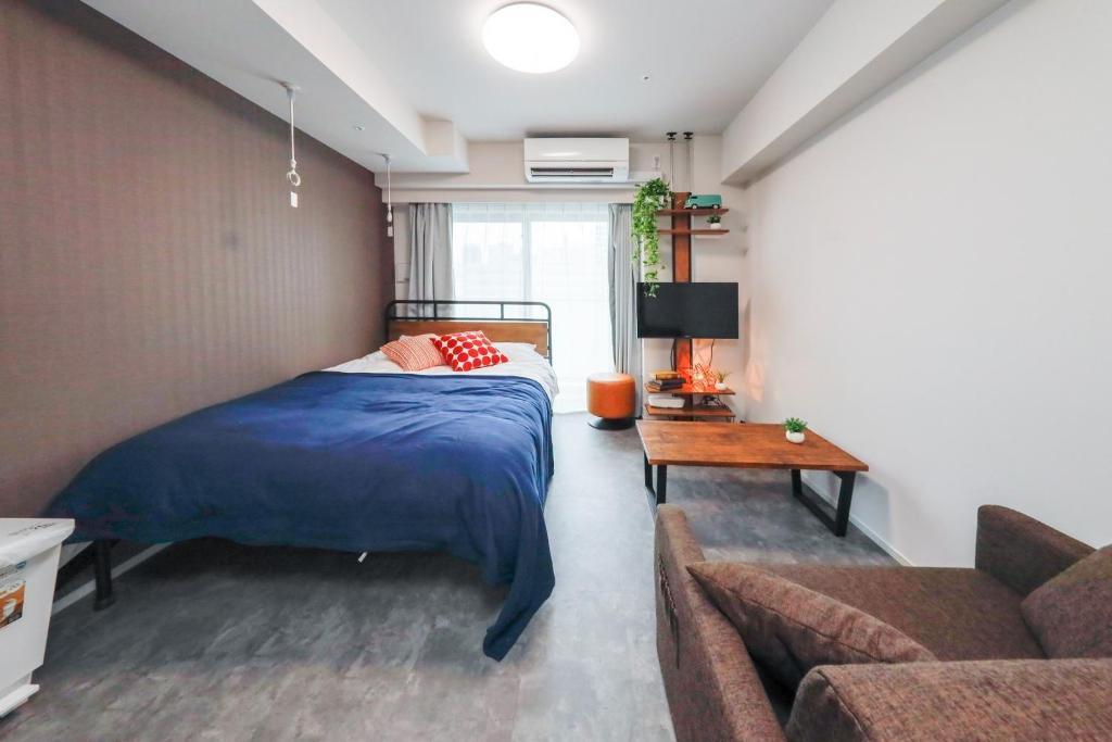 a bedroom with a bed and a couch at Seaside Tamachi - Vacation STAY 15584 in Tokyo