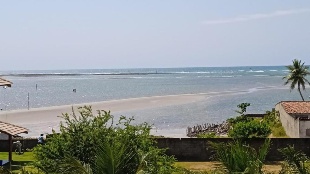 uma vista para uma praia com o oceano em Flats Sol e Mar em São José da Coroa Grande