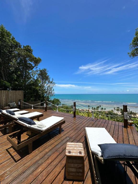 una terraza de madera con tumbonas y la playa en Pousada Santo Mar, en Arraial d'Ajuda