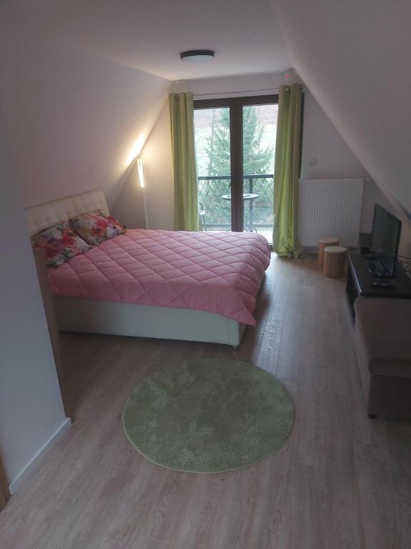 1 dormitorio con cama rosa y ventana en Vikendica Tuzla, Dolina mira en Tuzla