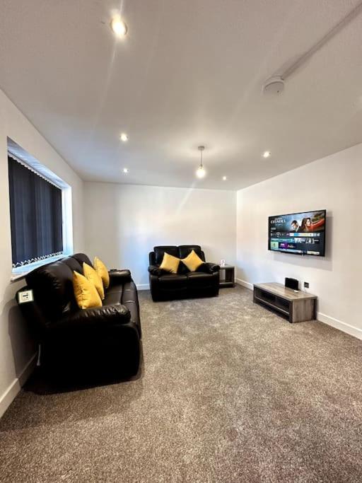 a living room with two couches and a flat screen tv at Brand New 3 bedroom House in Gated Development! in Polesworth