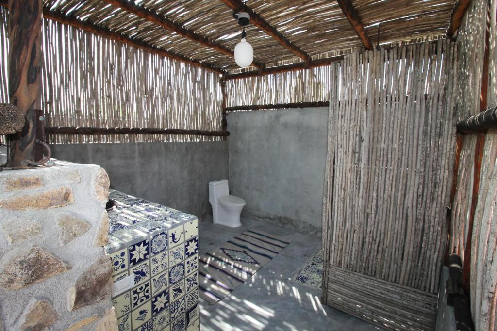 een badkamer met een toilet in een strooigebouw bij Pericu Bed and Garden in La Ventana