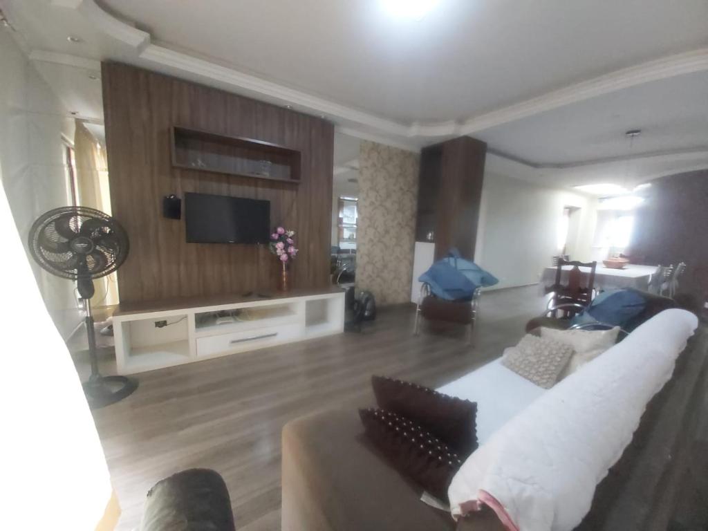 sala de estar con sofá y TV en Apartamento Margarida en Foz de Iguazú