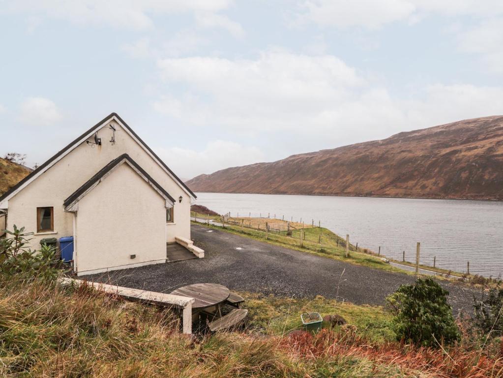 a small white building on the side of a lake at Tigh na Creag in Sconser