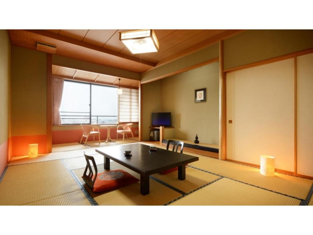 ein Wohnzimmer mit einem Tisch und Stühlen in der Unterkunft Tendo Grand Hotel Maizuruso - Vacation STAY 36011v in Tendō