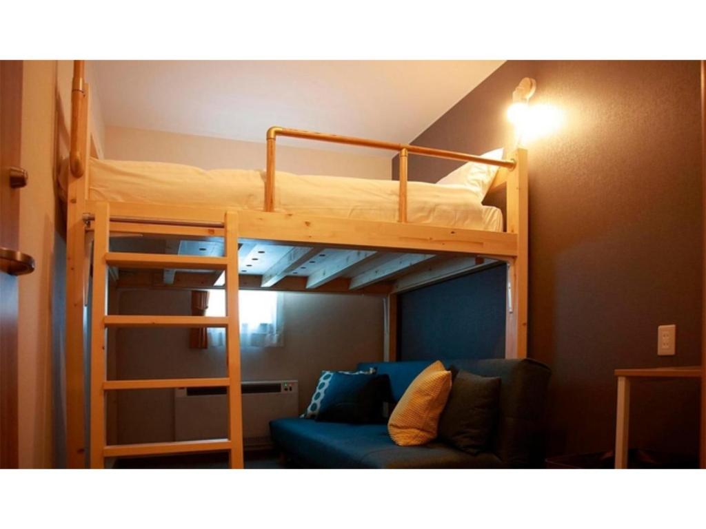 Etagenbett mit Sofa in einem Zimmer in der Unterkunft THE STAY WAKKANAI - Vacation STAY 40658v in Wakkanai
