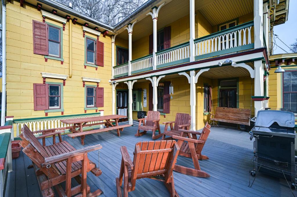 una casa con un patio con mesas y sillas de madera. en Historic Chambersburg Home with Pool and Game Rooms!, en Chambersburg