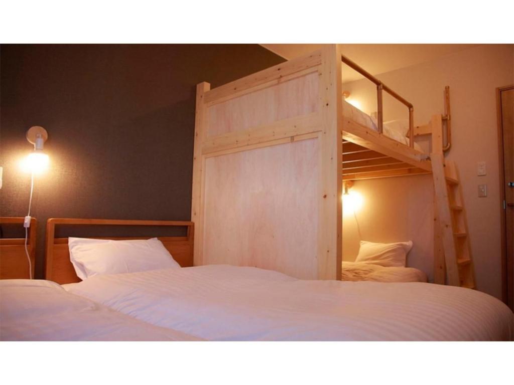 1 Schlafzimmer mit 2 Betten und 1 Etagenbett in der Unterkunft THE STAY WAKKANAI - Vacation STAY 40685v in Wakkanai
