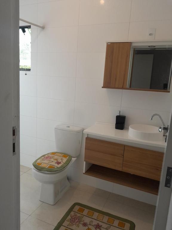 a bathroom with a toilet and a sink at Casa mariscal in Bombinhas