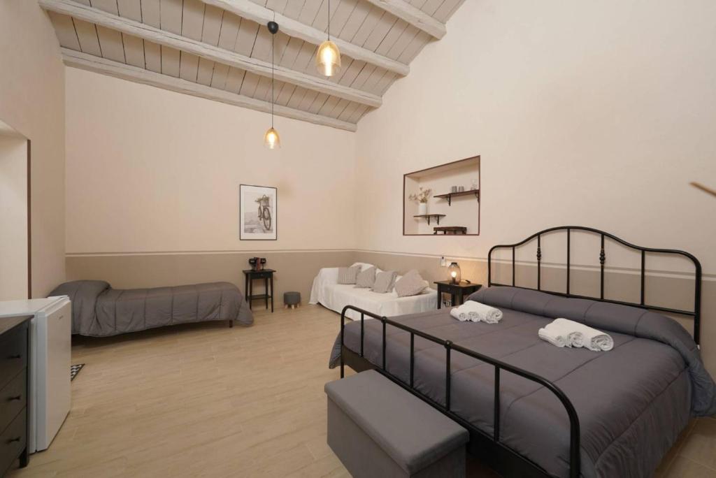 a bedroom with a bed and a living room at SyracuseApartments Antica Dimora in Siracusa