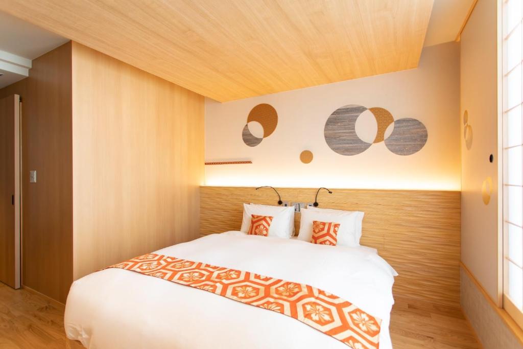 een slaapkamer met een wit bed en een houten hoofdeinde bij Higashiyama Hills - Vacation STAY 41300v in Kyoto