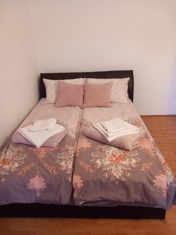 a bed with two pillows on top of it at Apartman Armenia in Vrnjci