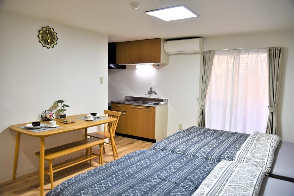 Cet appartement comprend une chambre avec un lit et une table ainsi qu'une cuisine. dans l'établissement YūshukuFushimi Inari - Vacation STAY 41346v, à Kyoto