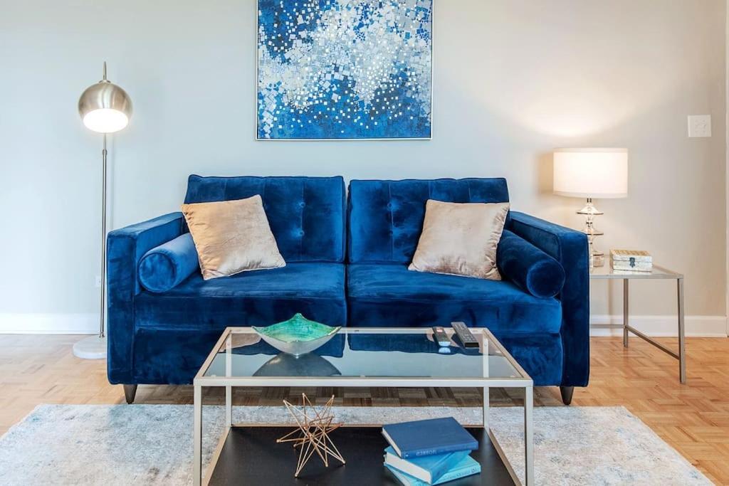 Sofá azul en la sala de estar con mesa de cristal en Condo With Skyline Views Near Peachtree Center, en Atlanta