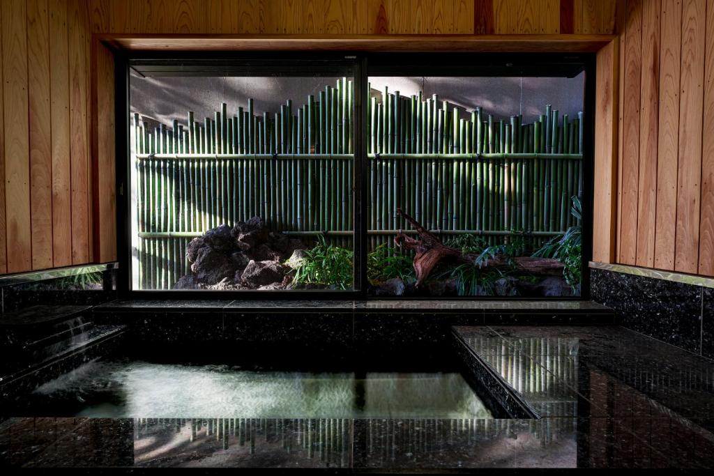 een kamer met een raam met een aquarium bij AMAO VILLA 熱海 in Atami