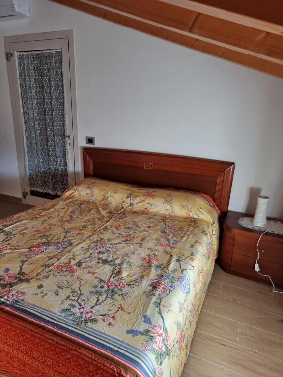 een slaapkamer met een bed met een houten hoofdeinde bij In campagna in Visnadello