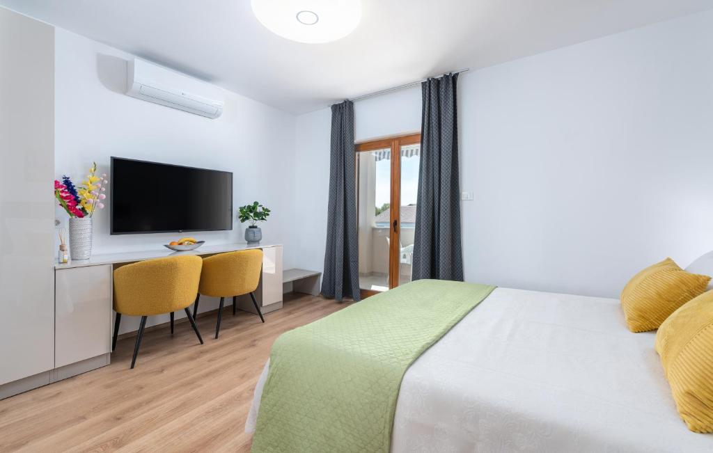 1 dormitorio con 1 cama y escritorio con TV en Apartments Viktor en Poreč