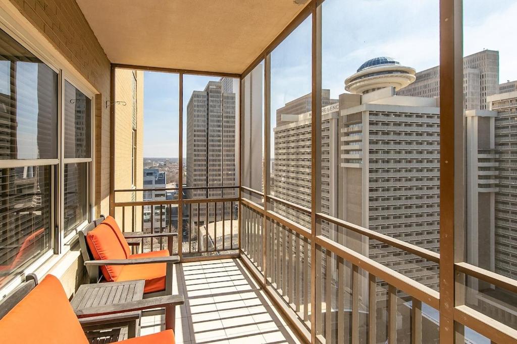 a balcony with orange chairs and a view of the city at High Rise Downtown Condo With Skyline View in Atlanta
